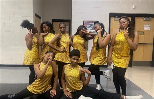 A group of eight diverse dancers from the Henry Ford High School 1st Dance Company pose together in 